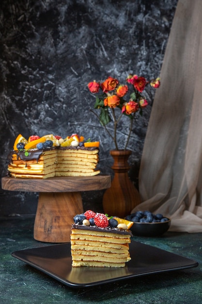 Front view yummy chocolate cake with fruits on dark wall