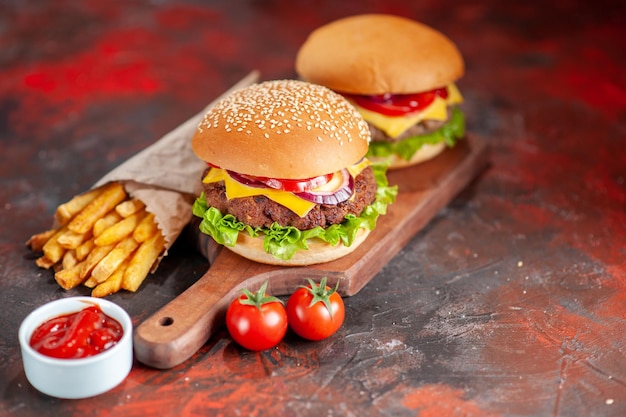 Front view yummy french fries with cheeseburgers on dark background snack dish fast-food sandwich dinner burger