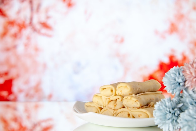 전면 보기 밝은 빨간색 배경에 맛있는 롤 팬케이크 아침 식사 케이크 설탕 디저트 아침 색상 우유 꽃 달콤한