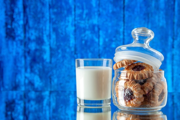 正面図明るい背景色のミルクのガラスが入った缶の中のおいしい甘いビスケットクッキーシュガーフード朝食ケーキ朝の食事