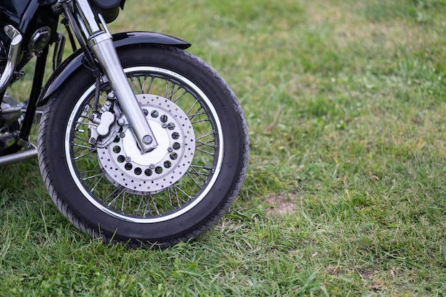 Front wheel of a motorbike on green grass