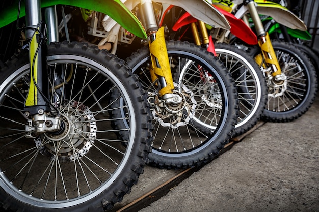 Front wheels of motorcycles stand in a row.