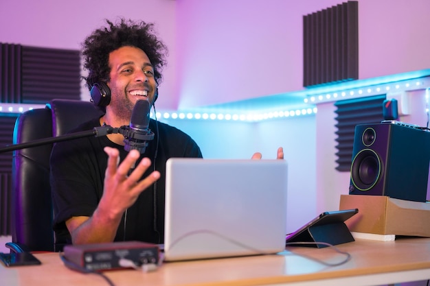 Frontal view of a content creator broadcasting a tutorial sitting on a music studio