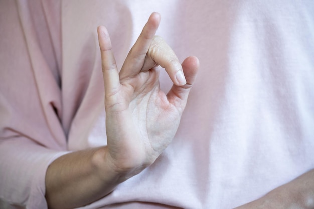 Frontal view of irrecognizable woman doing Vishnu mudra