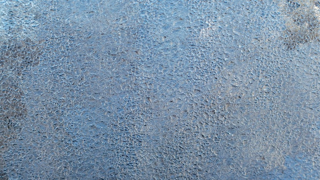 Frost patterns on frozen window as a symbol of Christmas wonder.