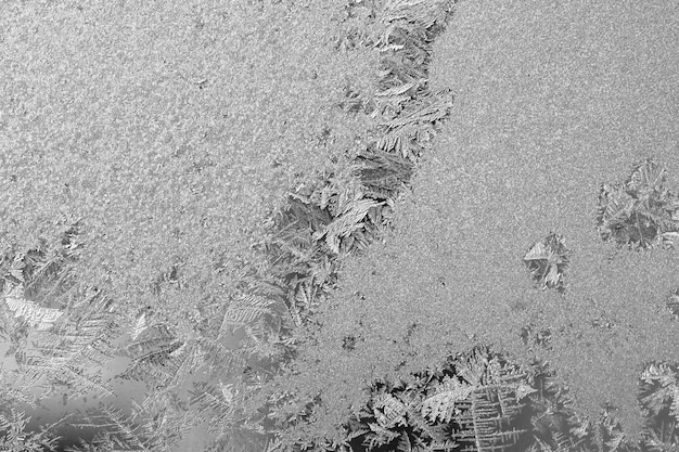 Frost on the window, Natural texture on glass with frozen pattern. Copy space, natural background, macro. Beautiful winter background