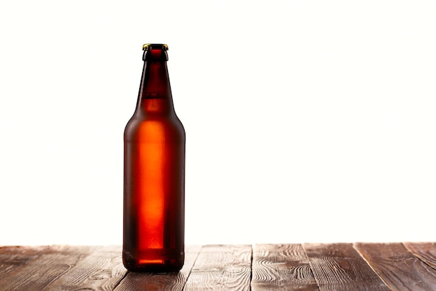 Матовая бутылка светлого пива на деревянном столе