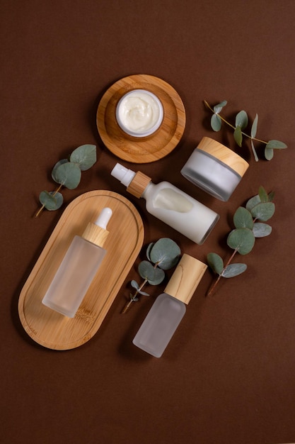 천연 화장품과 유칼립투스 (Eucalyptus) 를 담은 유리 유리 병과 항아리 화장실 테이블에 있는 나무 트레이에 있는 유기 화장품 세트