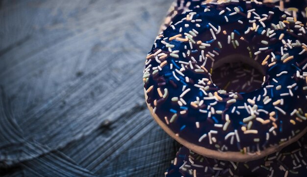 Frosted sprinkled donuts sweet pastry dessert on rustic wooden background doughnuts as tasty snack top view food brand flat lay for blog menu or cookbook design