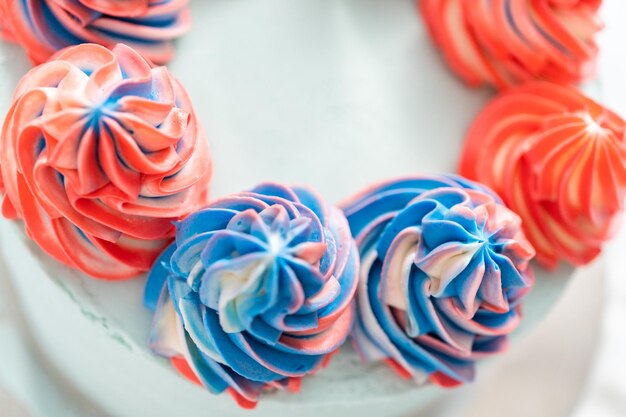 Frosting round vanilla cake with buttercream frosting for July 4th celebration.