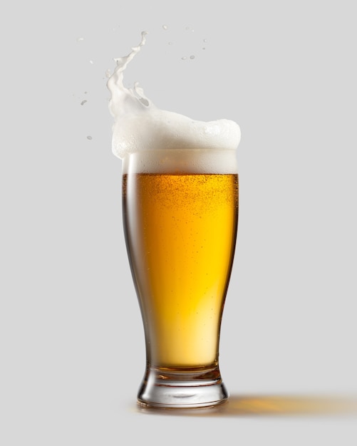 Foto bicchiere gelido di birra leggera con schiuma e schizzi, isolato su sfondo grigio