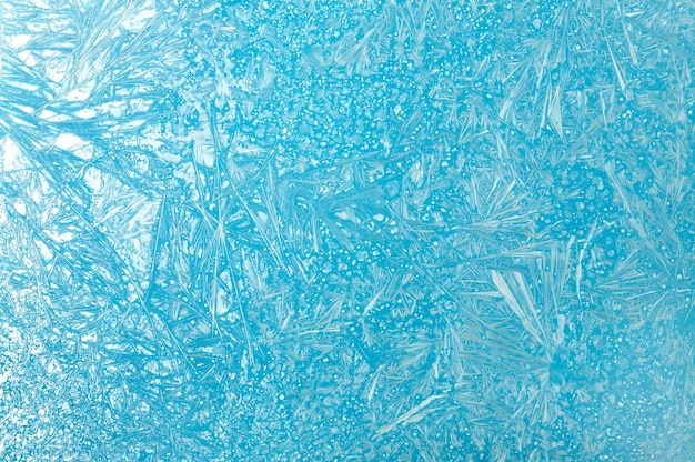 Frosty pattern on glass on a blue background