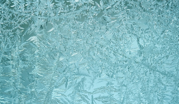 Frosty pattern on window glass. Winter blue wall