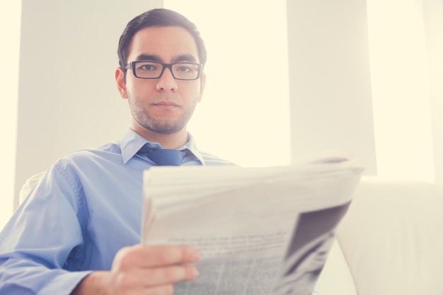 Foto accigliato uomo che guarda l'obbiettivo e tiene un giornale