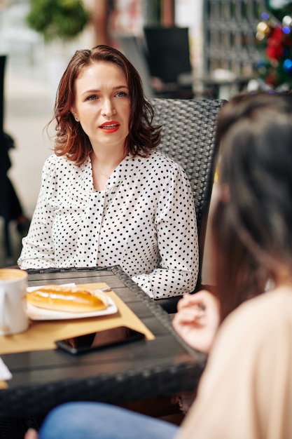 Frowning woman listening to friend