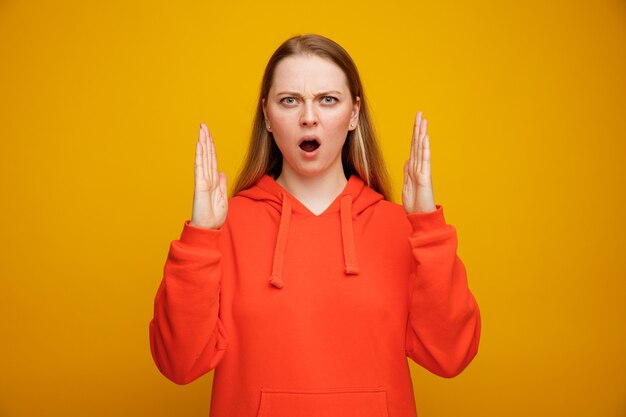 Frowning young blonde woman doing size gesture 