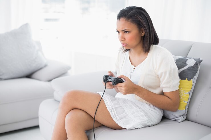 Photo ビデオゲームをする白い服の若い黒髪の女性を驚かせる
