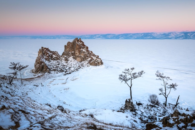 Frozen Baikal lake with snow in winter Siberia Russia Shamanka rock on Olkhon island