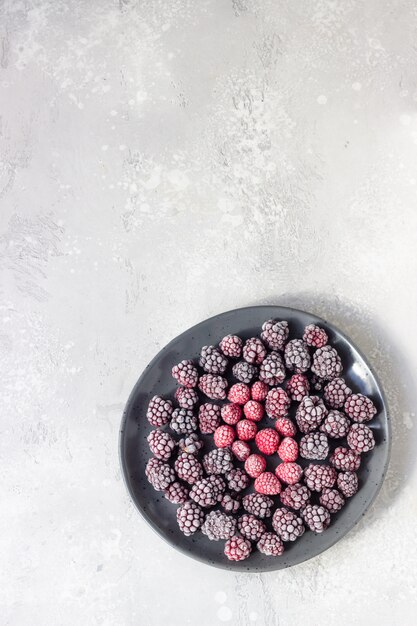 Замороженные ягоды (ежевика и малина), покрытые инеем