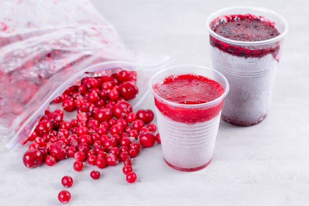 Frozen berry puree and frozen berries on white background