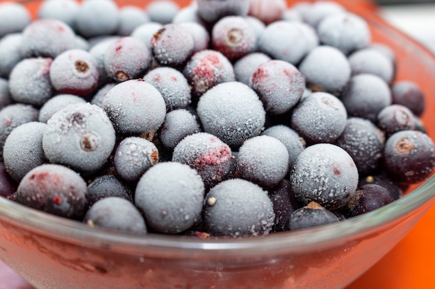 Frozen black currant berries in a glass jar 