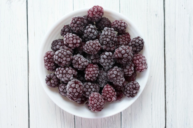 Frozen blackberries on a white background. Top view. Copy space.