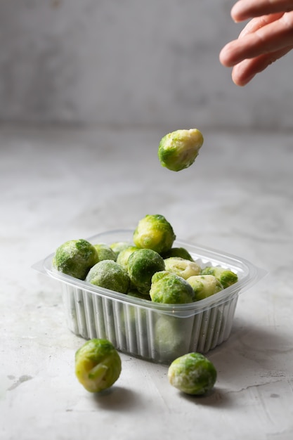 Photo frozen brussels sprouts in the storage boxe on the gray concrete space