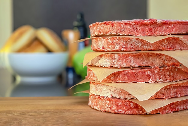 Carne di hamburger congelata sul tavolo prima di grigliare, scongelare prima di grigliare.