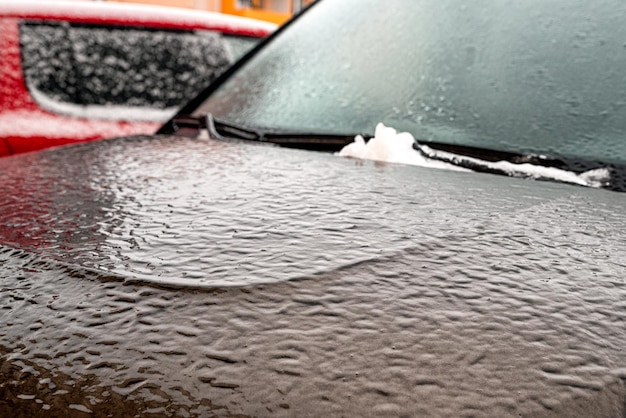 Frozen car covered by icy rain in winter