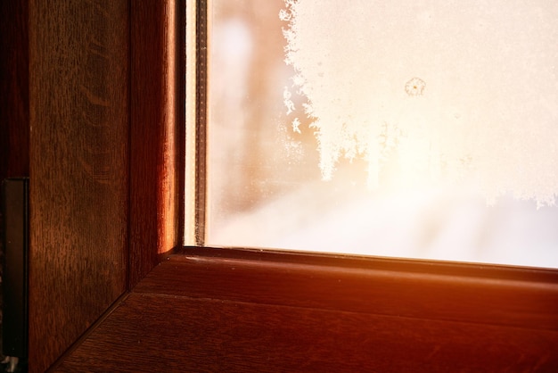 Frozen condensation on the interior window glass Iced steam and dew on the glass during winter