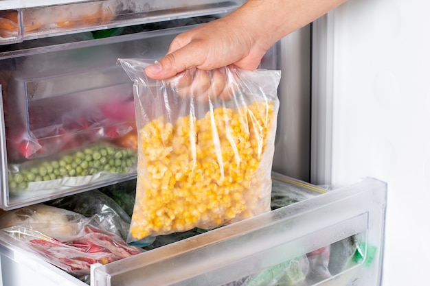 Frozen corn in plastic bags in the freezer. Frozen vegetables.