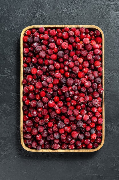 Frozen cranberries in a wooden bowl. 