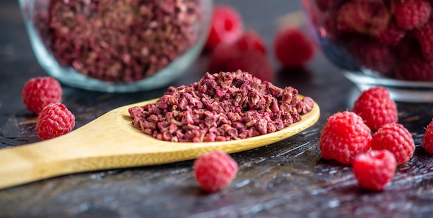 Frozen and dried raspberries on a wooden table