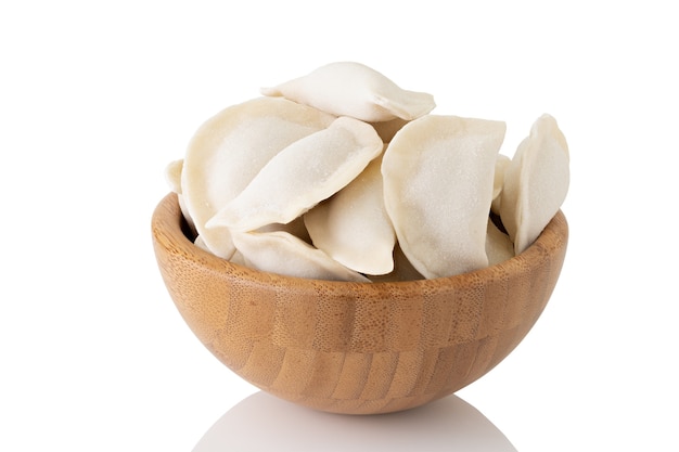 Gnocchi surgelati in ciotola di legno isolato su sfondo bianco