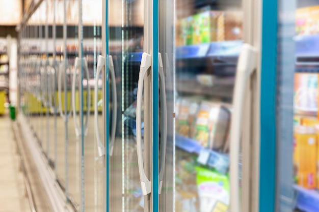 Frozen food and semifinished products in a glass refrigerator in a store Closeup Side view Blurred