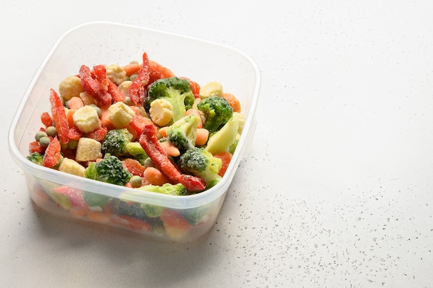 frozen food vegetables on white background close up copy space