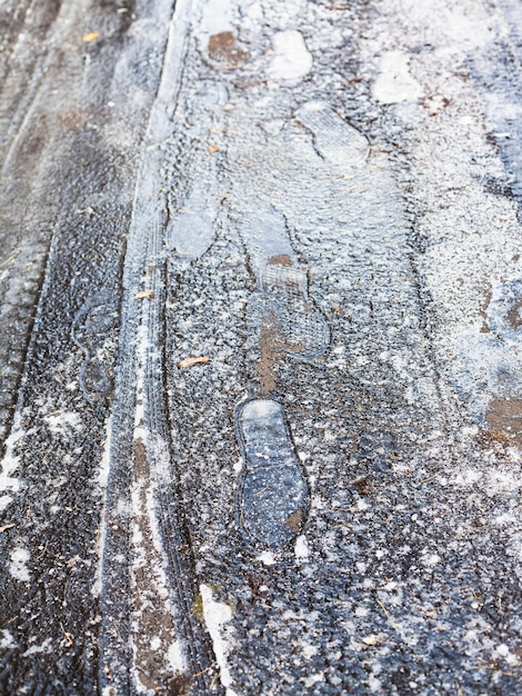Frozen footprints on surface of icecrusted road