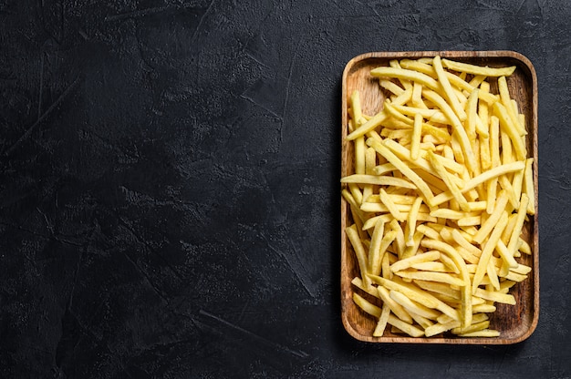 Frozen French fries in a wooden bowl. 