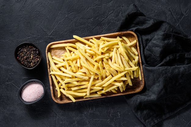 Frozen French fries in a wooden bowl. 