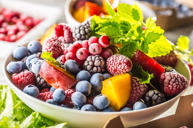 Frozen fruits blueberries blackberry raspberry red currant peach and herbs melissa.