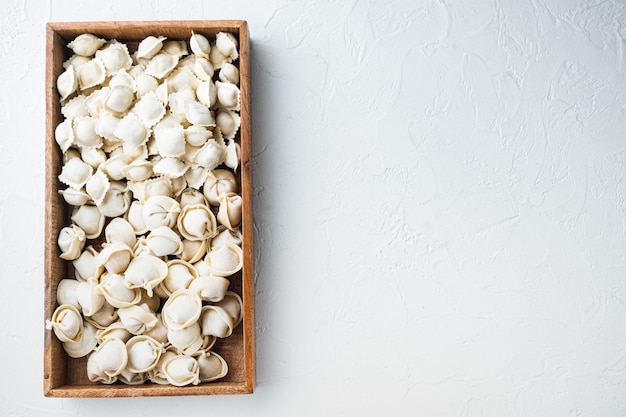 Frozen homemade tortellini ravioli set  in wooden box, on white background, top view flat lay , 