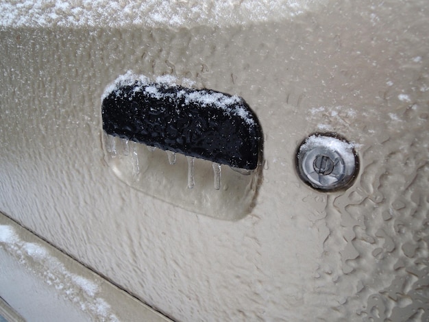 자동차 문 각도 보기의 핸들에 얼어붙은 열쇠 구멍과 고드름 스톡 사진