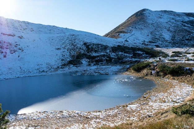 산속의 얼어붙은 호수 산속의 연못 눈 덮인 산 호수가 있는 풍경 겨울과 서리