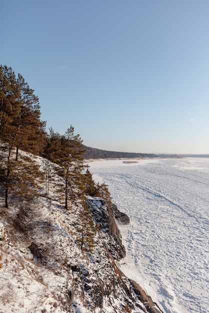 A frozen lake or river in winter. Near the forest and mountains in the snow. winter landscapes