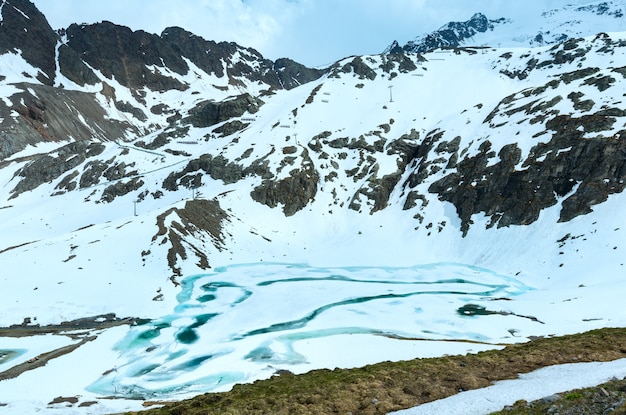 Замерзшее озеро летом в горах Альп (Австрия).