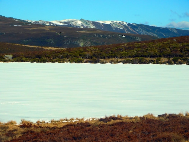 A frozen lake with mountains in the background.