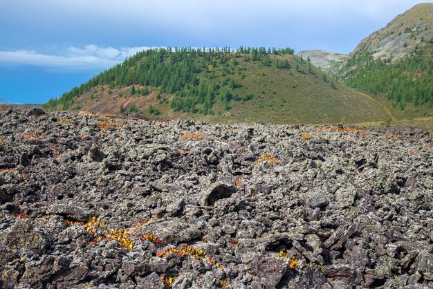 Foto campo di lava congelato nella valle del vulcano con il vecchio vulcano sullo sfondo