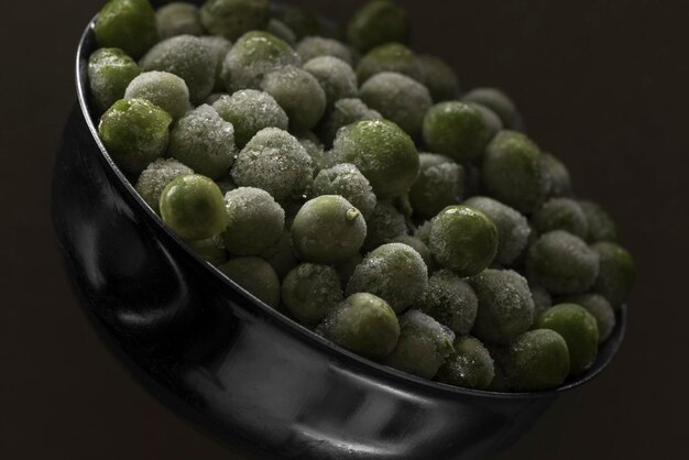 Frozen peas in a metal scoop