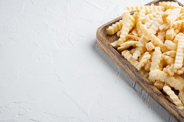 Photo frozen potatoes, french fries, canned food set, on wooden tray, on white background , with copyspace  and space for text