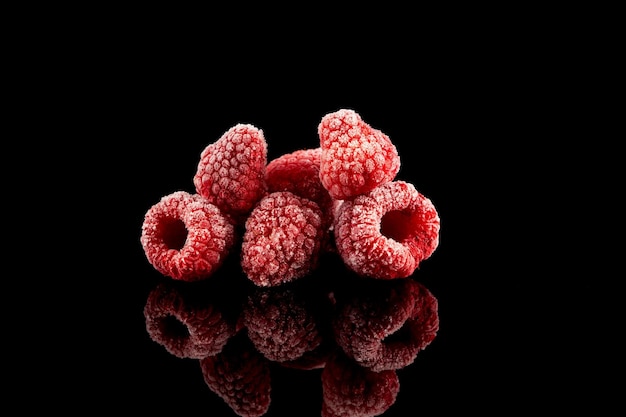 Photo frozen raspberries on dark background clever storage food selective focus